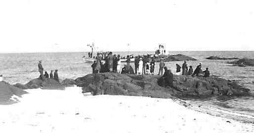 Familias reunidas en las rocas a orillas del mar