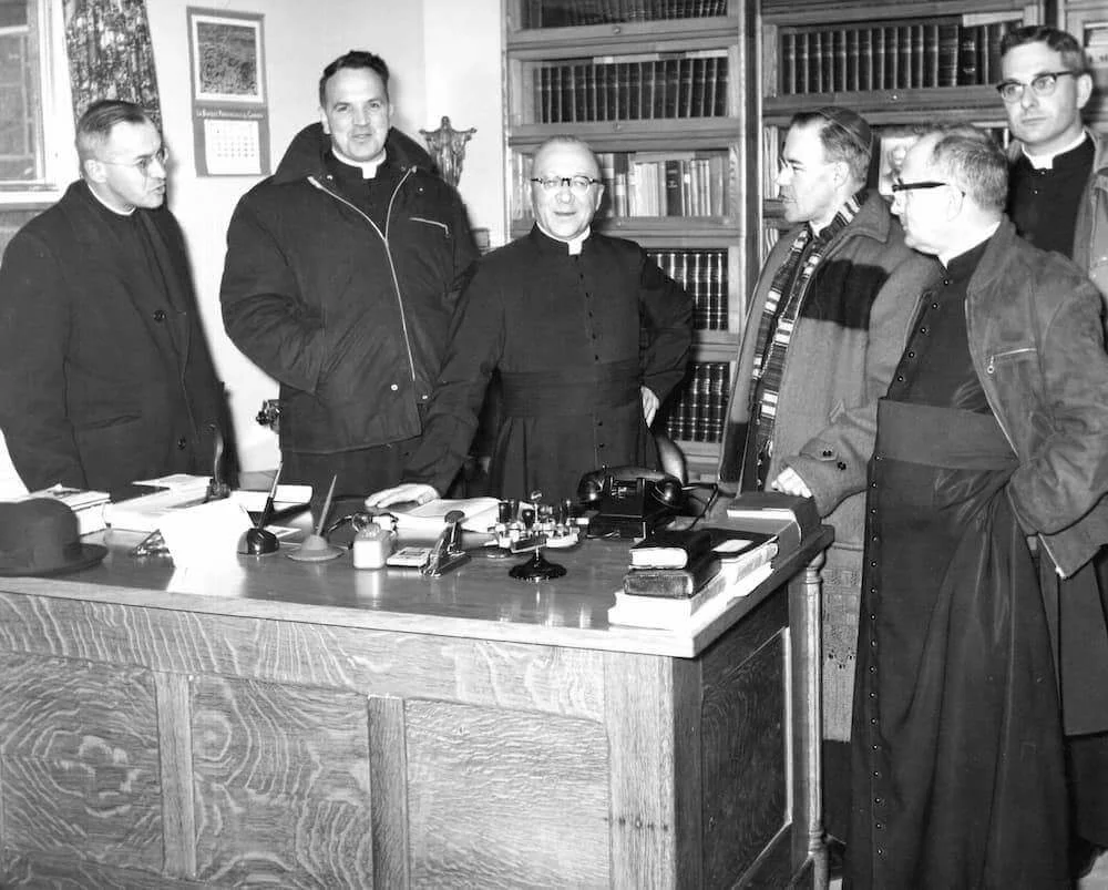 Mons. Couturier y los miembros de la visita reunidos en una oficina del astillero